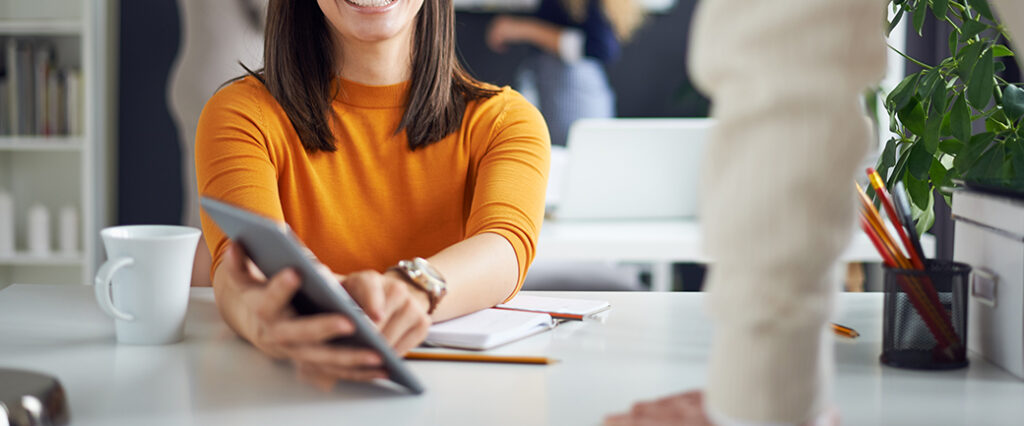 A woman points to a tablet screen