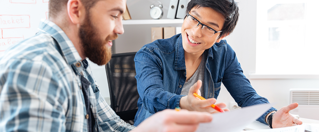 Two colleagues discuss a printout