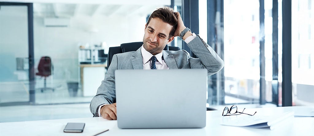 Confused office worker looking at laptop on why customer journey map failed to drive change