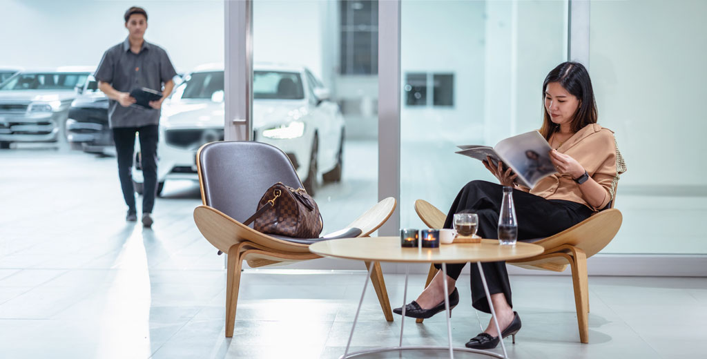 Woman waiting for her car to be serviced at the dealership