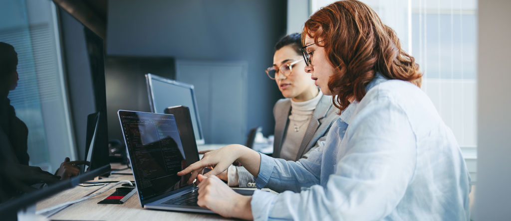customer experience teammate showing an intern an example on her screen