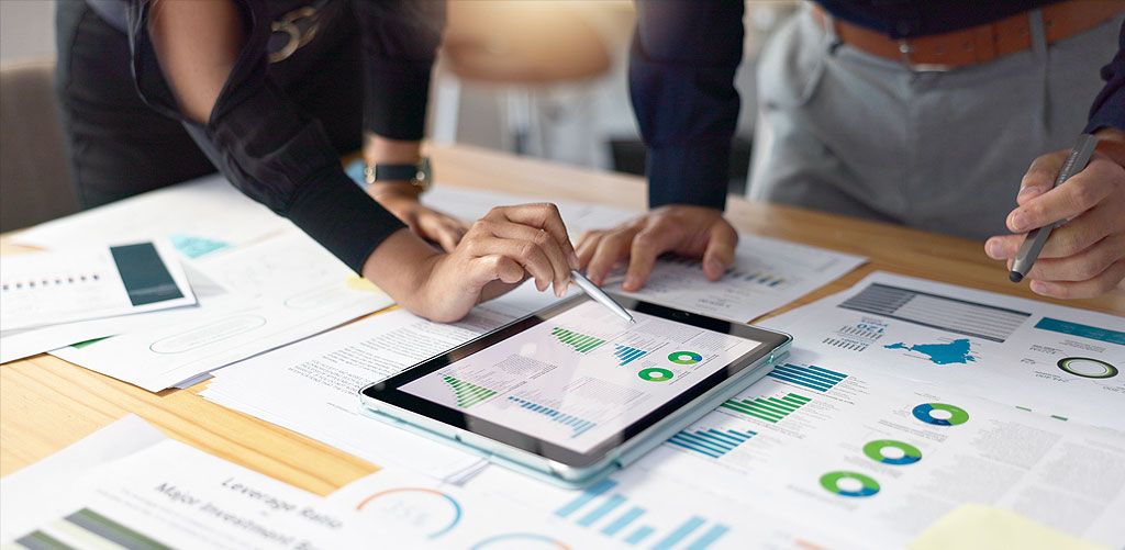 Two people treating data as a capital investment by reviewing business charts and graphs