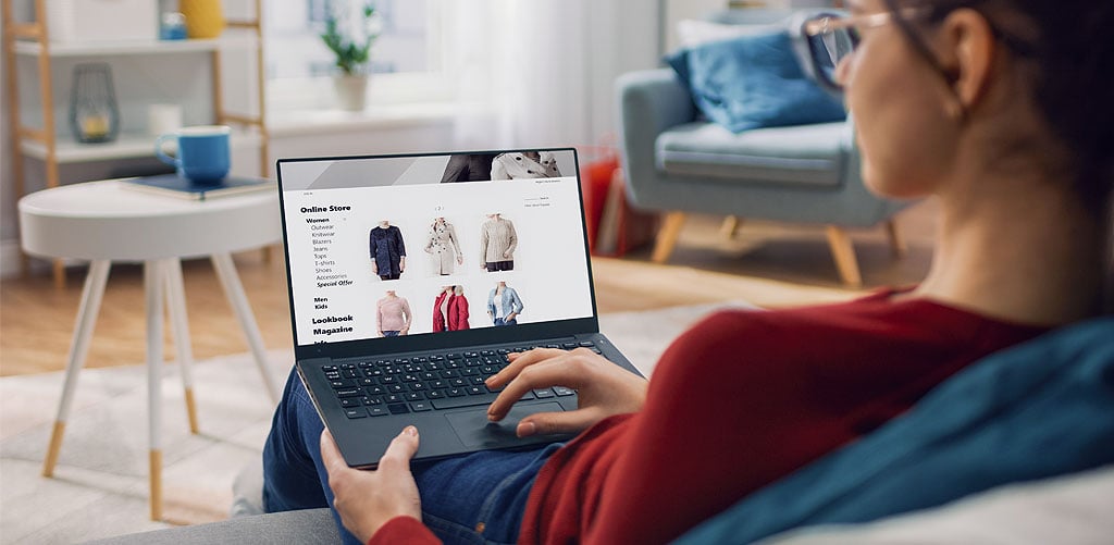Woman using a laptop to browse an online clothing store to represent types of behavior data created by users