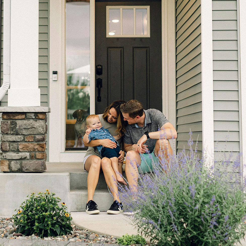 Bozzuto client story family sitting on their porch of their home